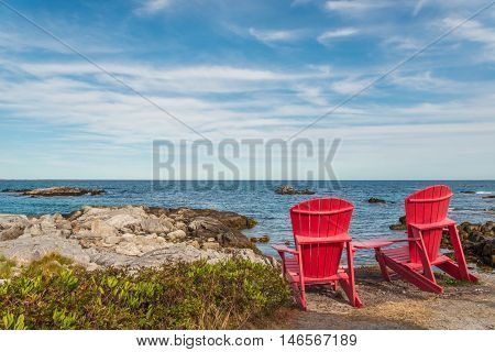 Red chairs facing Keji Seaside beach (South Shore Nova Scotia Canada)