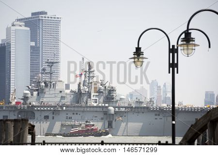 JERSEY CITY NJ - MAY 31 2016: USS Bataan (LHD 5) on the Hudson River passes Lower Manhattan upon departing Manhattan marking the end of Fleet Week 2016 as seen from Liberty State Park.