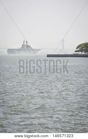 JERSEY CITY NJ - MAY 31 2016: USS Bataan (LHD 5) passes Liberty Island on the Upper New York Bay upon departing Manhattan marking the end of Fleet Week 2016, seen from Liberty State Park.