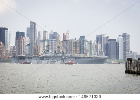 JERSEY CITY NJ - MAY 31 2016: USS Bataan (LHD 5) on the Hudson River passes Lower Manhattan upon departing Manhattan marking the end of Fleet Week 2016 as seen from Liberty State Park.