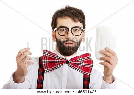 Shocked man holding menstruation pad.