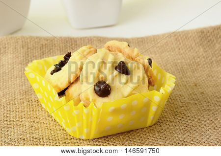 Chocolate chip cookies on brown colored cloth on white table