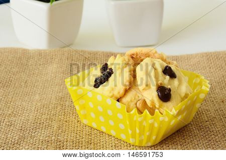 Chocolate chip cookies on brown colored cloth on white table