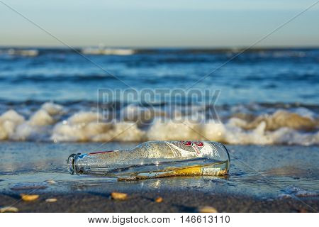 Kijkduin beach the Netherlands - September 10 2016: empty bottle lying in the surf