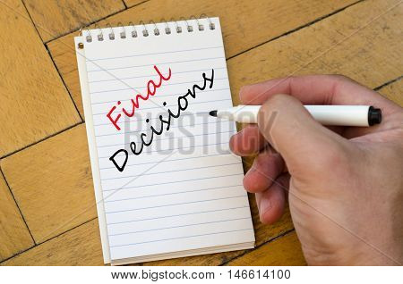 White notepad and human hand on the wooden background