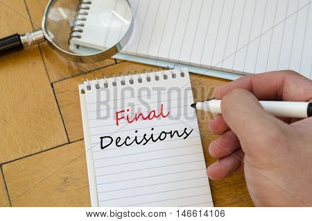 White notepad and human hand on the wooden background