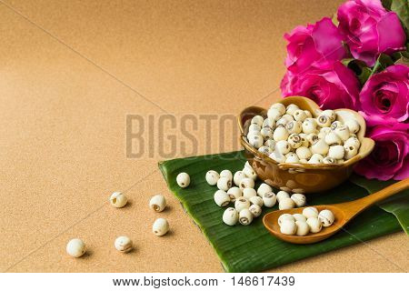 Lotus seed in ceramics cup on banana leaf cork wood texture background
