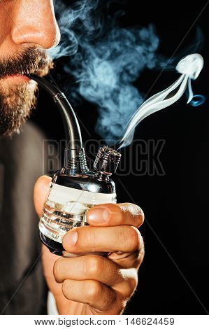 Man smoking marijuana using a glass pipe