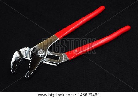 pliers or wrench red handle on dark background