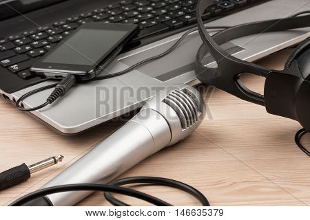Laptop microphone headsets lies on a wooden table background top view