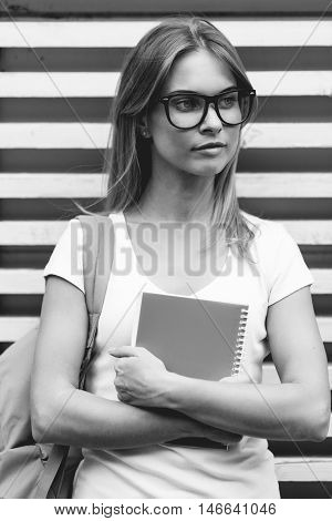 Young woman folded arms stands at wooden fence.black and white photo