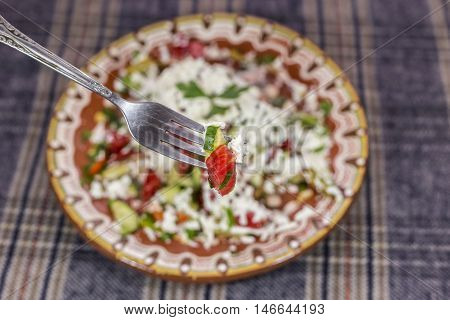 Macro Shot Of Shopska Salad On A Fork.