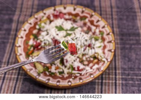 Macro Shot Of Shopska Salad On A Fork.