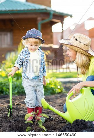 Portrait of a child boy working in the garden in holiday