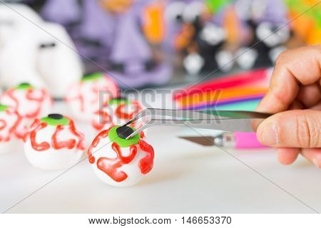 Confectioner working on the figures of Halloween with fondant paste