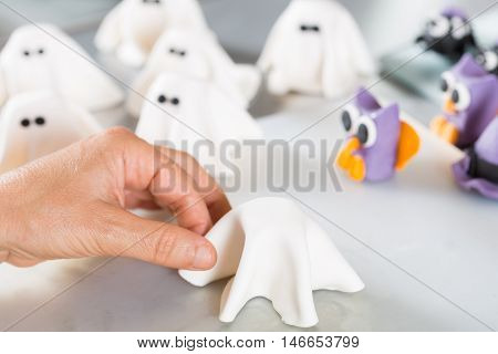 Confectioner working on the figures of Halloween with fondant paste