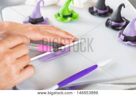 Confectioner working on the figures of Halloween with fondant paste