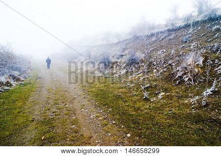 Person walking on misty pathway lonely walk
