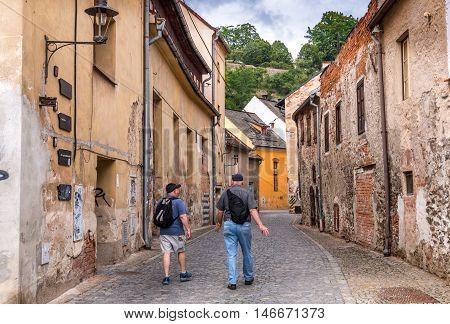 Two friends walking through back street in the town of Cesky Krumlov Czech Republic