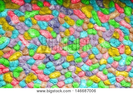 A colourful stone background texture. Bright red green blue orangeyellow