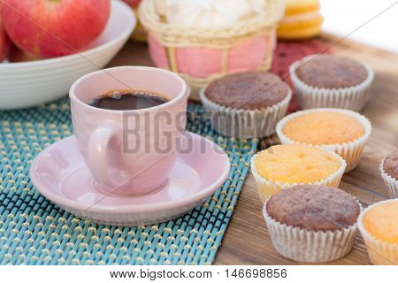 Still life of served coffee cups cup-cakes marshmallows and apples