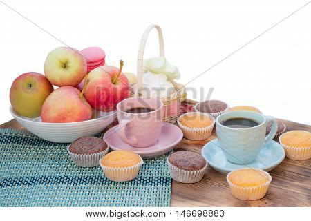 Still life of served coffee cups macaroon cookies marshmallows and apples