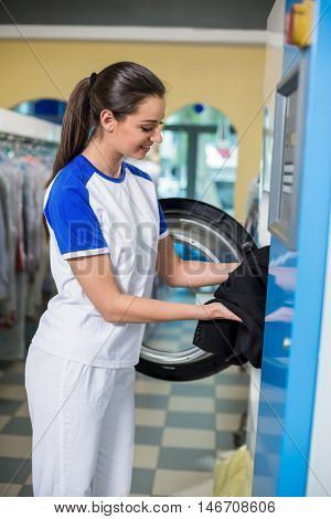 Employees putting clothes in the dryer in dry cleaner