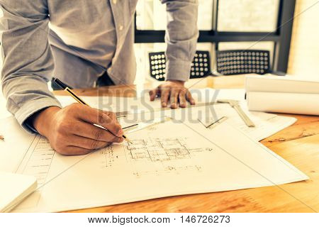 architect drawing architectural project on blueprint engineering concept architecture concept soft focus vintage tone