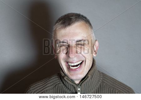 Stdio shot of a man bursting into laugh