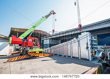 Mobile crane operating by lifting and moving an heavy electric generator