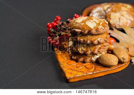 Typical Dutch filled spicy cookies with almonds on autumn colored and dark background