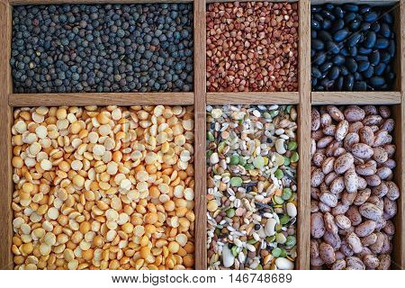 Collection assorted of lentils beans peas grain groats soybeans legumes in wooden box