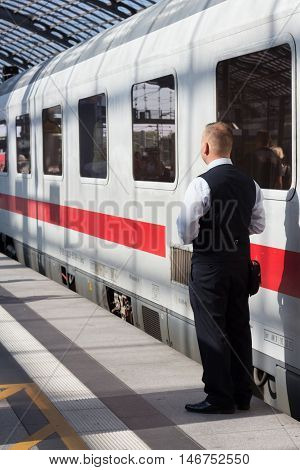 Berlin Germany - September 9 2016: Train conductor from behind standing in front of ice train at central staion in Berlin.