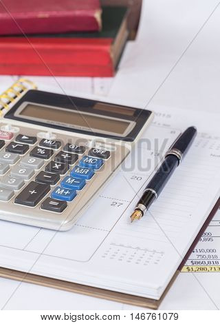 calculate and pen on calendar book on table