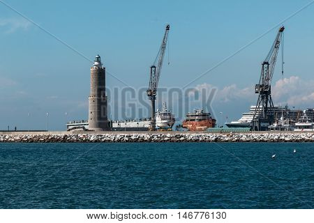 Cranes at Work in Boatyard near Lighthouse