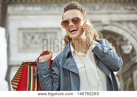 Woman With Shopping Bags Talking On A Smartphone In Paris
