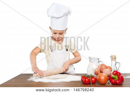 Happy little chef smeary with flour stretching the dough