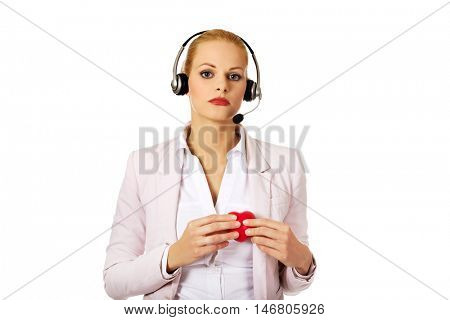 Unhappy call center woman holdinh heart model