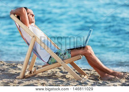business man working with tablet on the beach