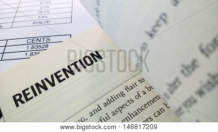 Reinvention word on the book with balance sheet as background
