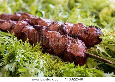 Pork kebab on skewers with fresh herbs