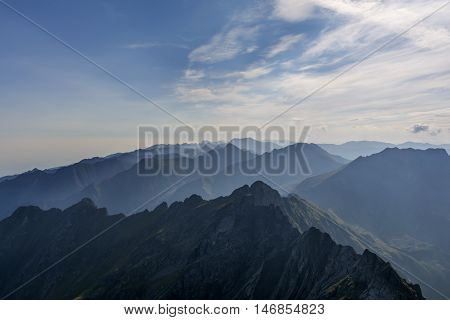 Silhouette of evening mountains in fog. View of Moldoveanu peak, the highest peak from Romanian Carpathian Mountains range.
