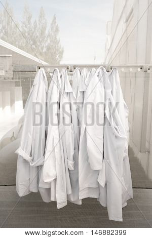 hanging farm lab coats in glasshouse wait for clean