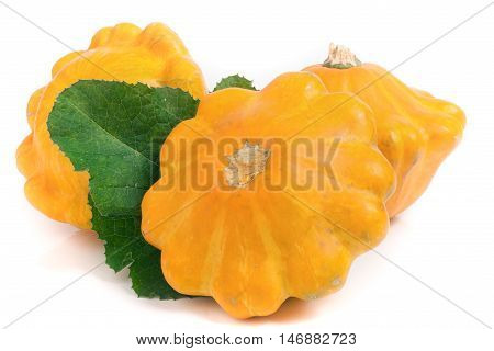 three yellow pattypan squash with leaf isolated on white background.