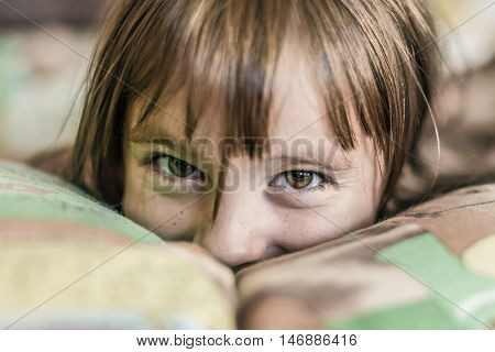 Portrait of a happy child in bed in the morning.