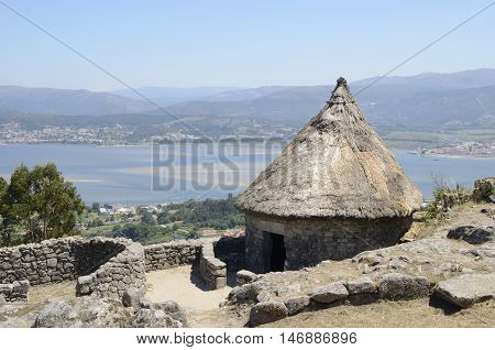 One of the reconstructed houses in the remains of a celtic settlement in Santa Tecla Mount in Galicia Spain with views to the MInho Estuary.