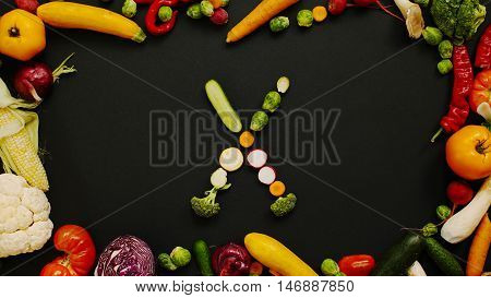 Vegetables made letter X.  Autumn harvest generates letters. Tomatoes, cabbage, peppers and other vegetables on a black background.