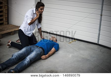 girl calling the emergency service for an unconscious man