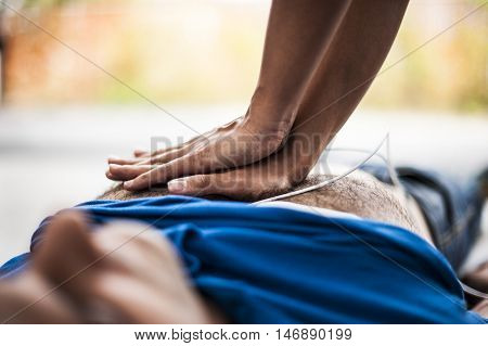 girl making CPR and heart massage to an unconscious man