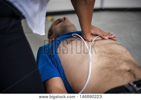 girl making CPR and heart massage to an unconscious man
